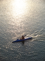 Kayak floating down a river with sun sparkling on the water